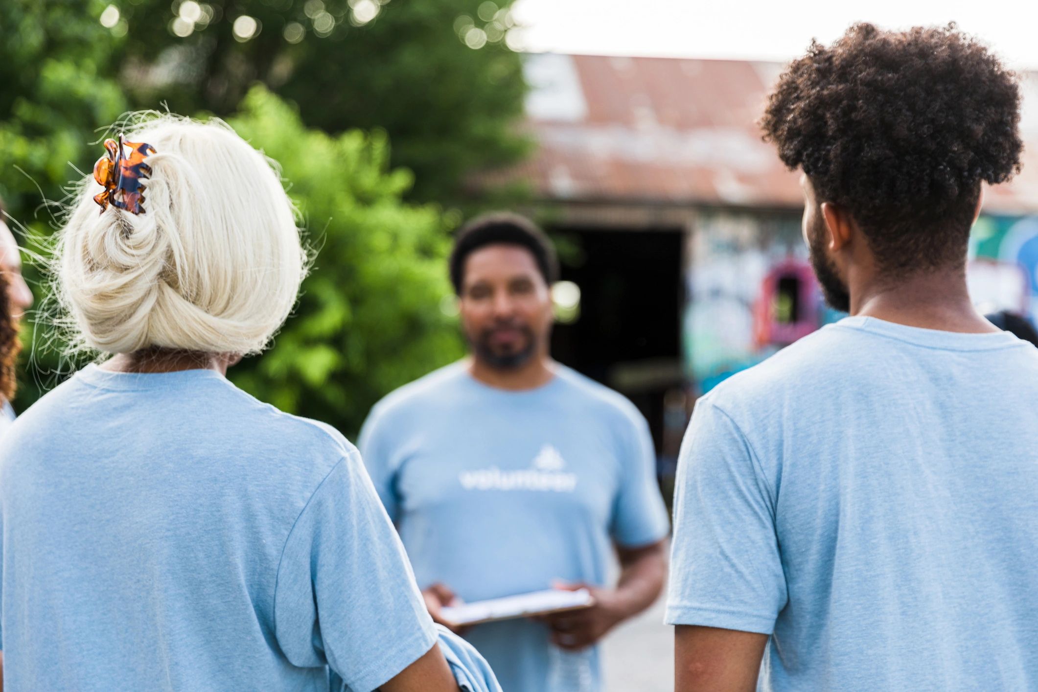 Volunteers listening to a speaker at a community service event