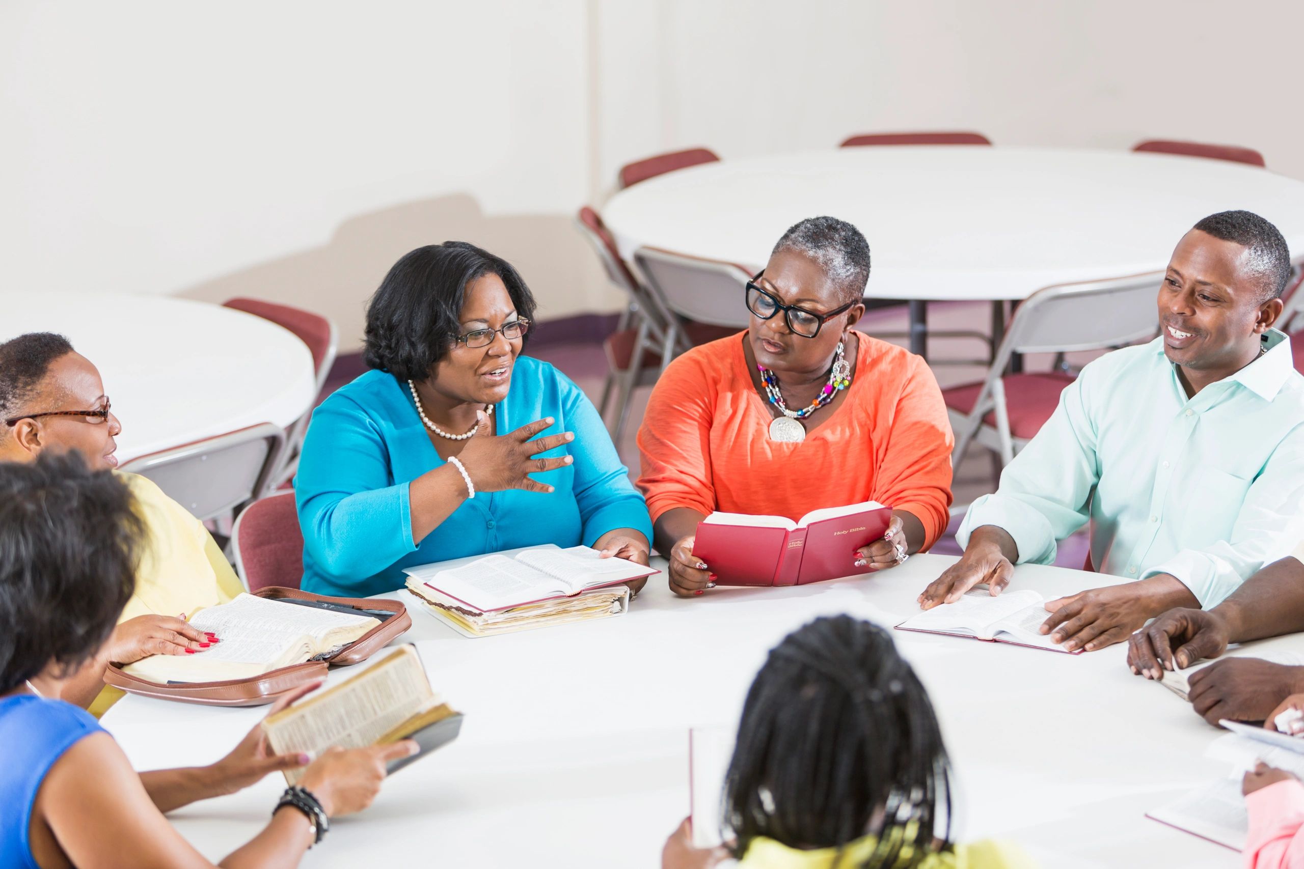 Bible study group gathered around a table with open Bibles